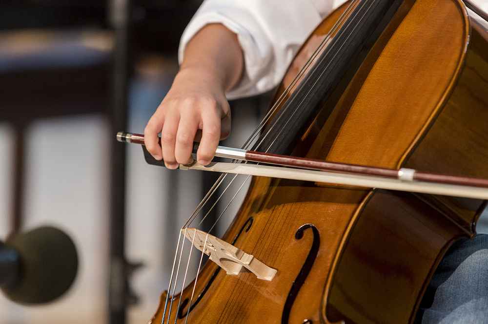 Cello player performing with a close up of the bow
