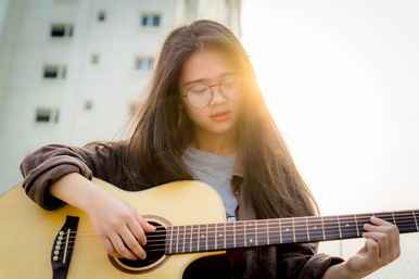 A girl playing the acoustic guitar