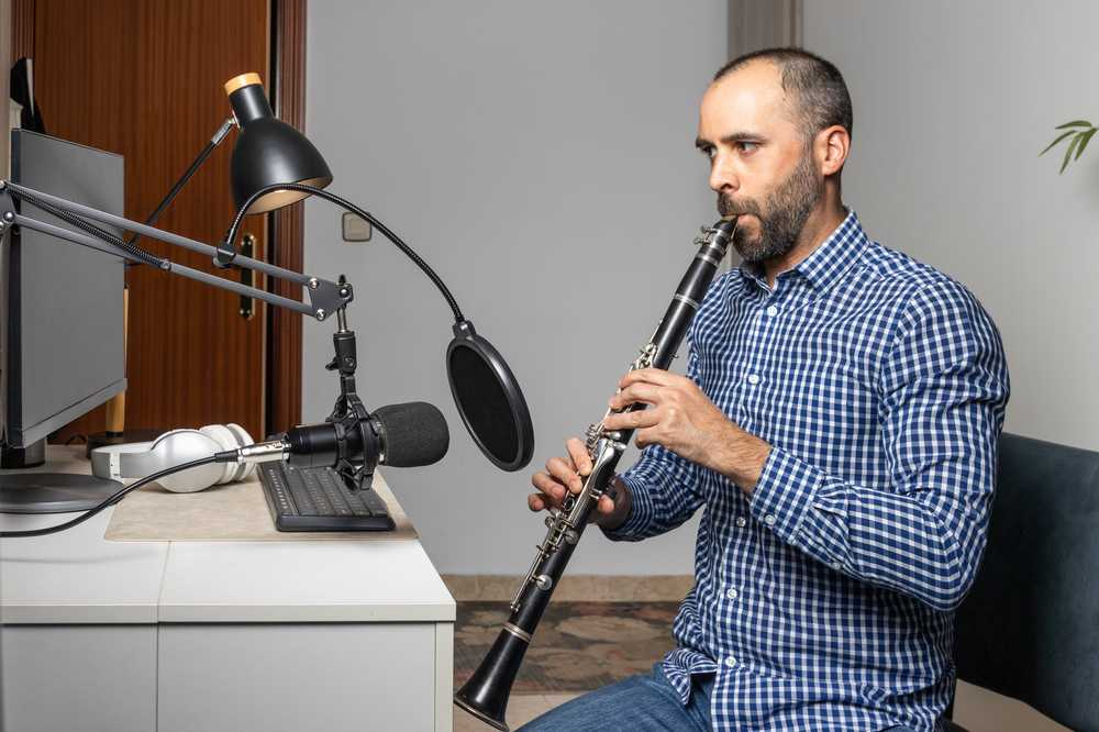 A man giving a clarinet lesson online