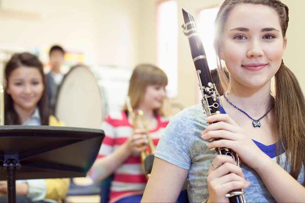 A young girl holding a clarinet